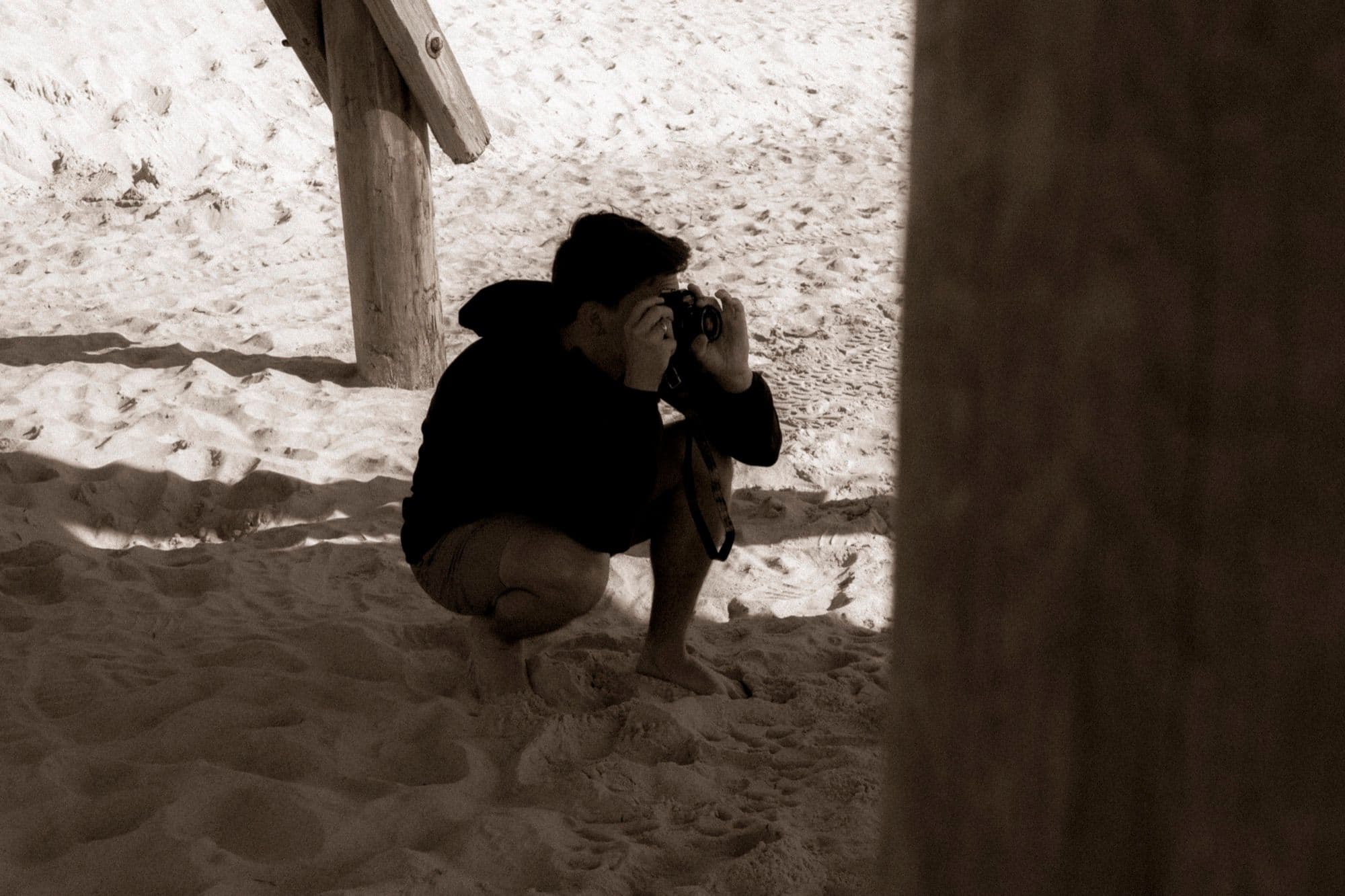 David crouched on the sand, taking a photo