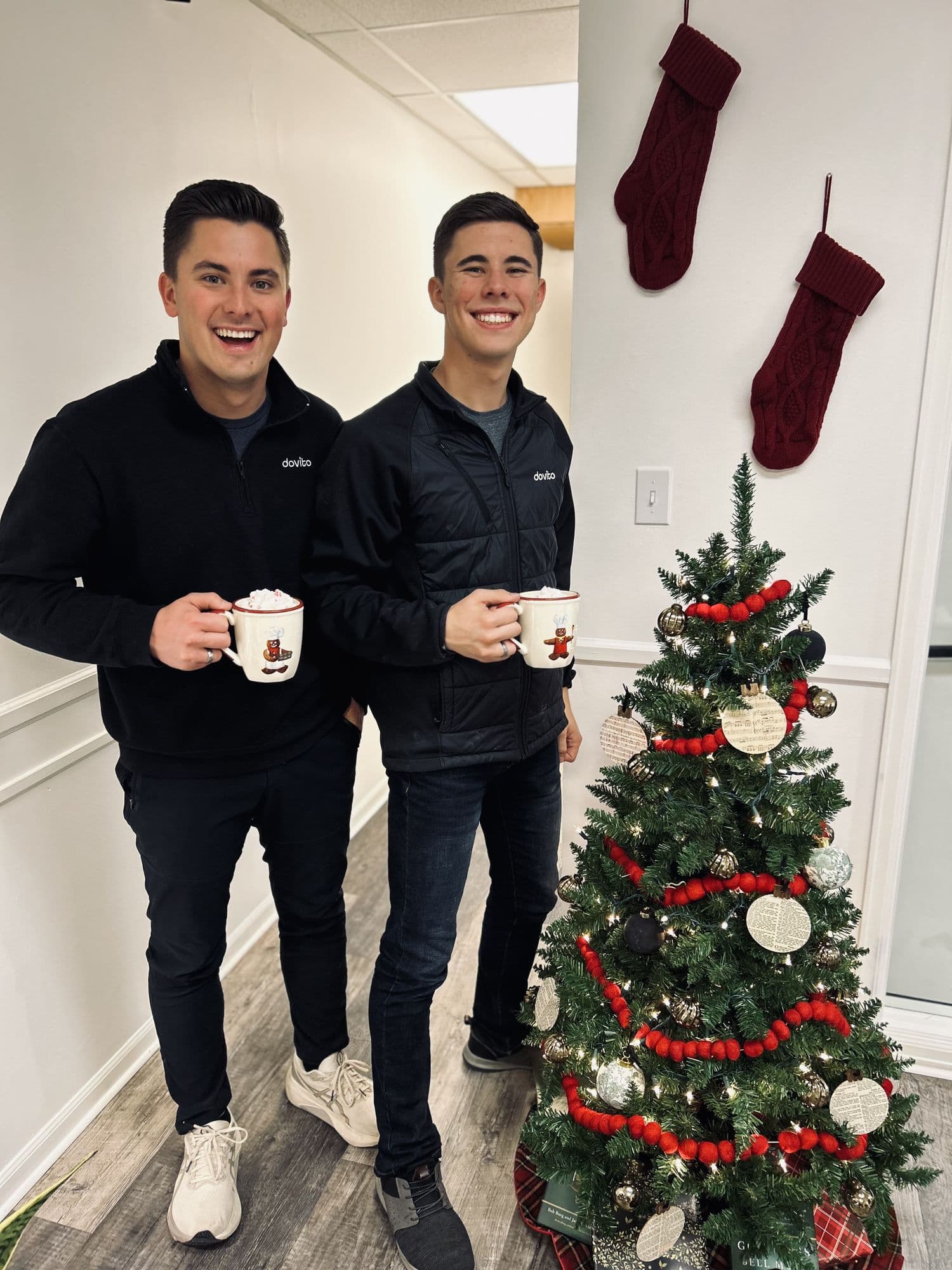 David and his brother Matthew with mugs by a Christmas tree
